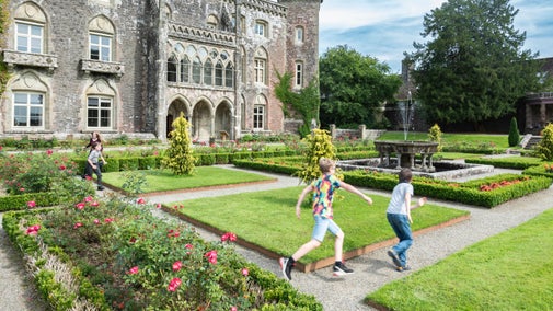 Children running amongst the borders in the formally laid out garden at Dinefwr, Carmarthenshire